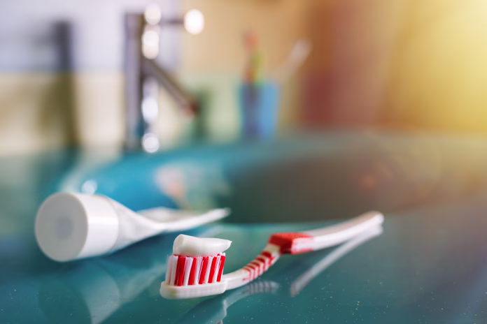 teeth-health-brush-and-toothpaste-on-blue-sink-in-bathroom-red-toothbrush-lies-in-the-interior-on-background-of-water-tap-stockpack-istock teeth health: brush and toothpaste on blue sink in bathroom. red toothbrush lies in the interior on background of water tap.