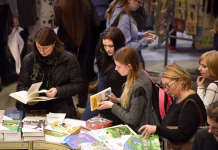 Knjigarna Felix se ne šali, v Slovenijo prihajata knjižna zvezdnika VILNIUS - FEBRUARY 26: Many people choose books at the indoor book market on February 26, 2016 in Vilnius, Lithuania. Vilnius is the capital of Lithuania and its largest city.