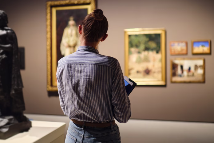visitor-in-historical-museum-looking-at-art-object-stockpack-istock Visitor in historical museum looking at art object.