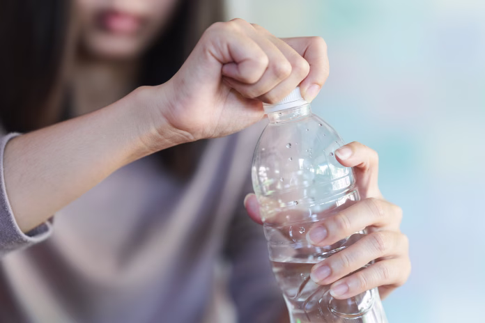 women-holding-drinking-bottle-and-opening-the-cap-of-a-water-bottle-to-drink-water-stockpack-istock Women holding drinking bottle and opening the cap of a water bottle to drink water.