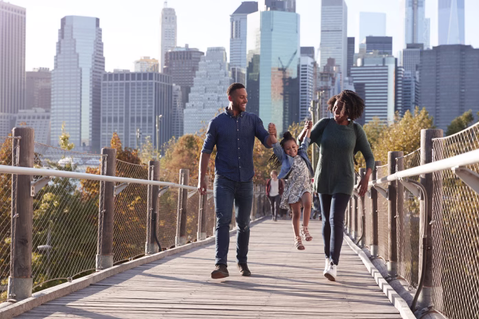 young-family-with-daughter-taking-a-walk-on-footbridge-stockpack-istock Young family with daughter taking a walk on footbridge