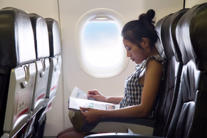 Young woman sits in a chair of the airplane
