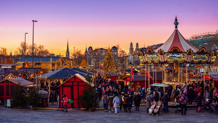 Zurich, Switzerland - November 23, 2023: Christmas market in front of the opera house at the Sechselautenplatz square-Bellevue in Zurich at sunset