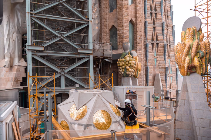 Barcelona, Spain - April 19 2022: Construction workers working at detailed decorating golden pieces at Sagrada Familia in Barcelona