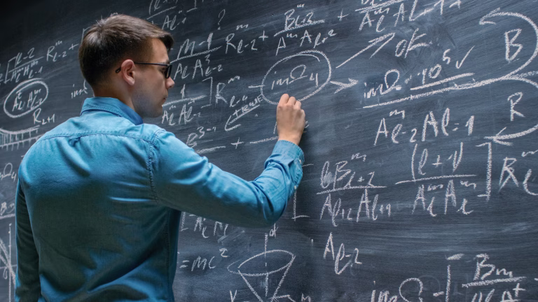 Brilliant Young Mathematician Approaches Big Blackboard and Finishes writing Sophisticated Mathematical Formula/ Equation.