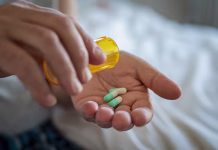 Znanstveniki po naključju odkrili nov antibiotik Closeup of man hand pouring capsules from a pill bottle into hand. Senior man taking daily medicine to consume. Close up of male hands taking daily dose of drug.