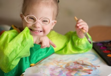 Ali bo vlada res izboljšala situacijo otrok s posebnimi potrebami? To so napovedali … Girl with Down syndrome covered in paint when drawing