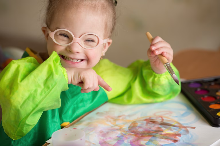 Girl with Down syndrome covered in paint when drawing