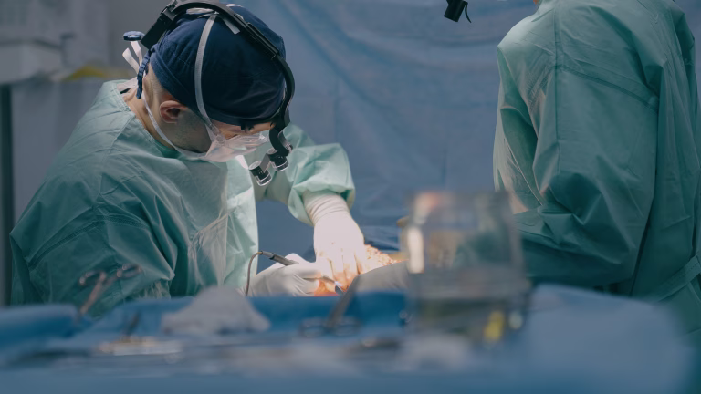 Group of surgeons men doctors physicians in medical masks process surgical operation trauma health treatment medicine aid plastic surgery with scalpel saving life patient in operating clinic hospital. High quality 4k footage