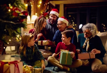 Ti običaji in praznovanja so prava katastrofa za okolje Happy multigeneration family enjoying in opening gifts on Christmas eve at home.