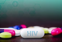 Velik preboj narejen pri zdravljenju ptičje gripe in HIV-a In this photo illustration pills of pharmaceutical drugs of various colors. Text HIV in one white pill. Healthcare and medicine concept.