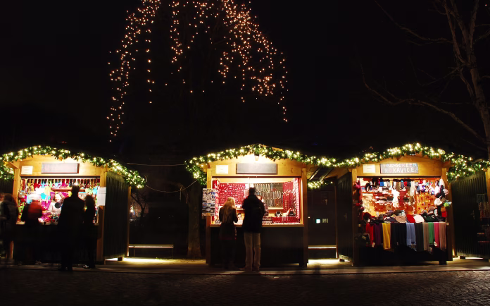 Ljubljana, Slovenia - December 11th 2015. Passersby stop to look at items for sale on Christmas market stalls in central Ljubljana.