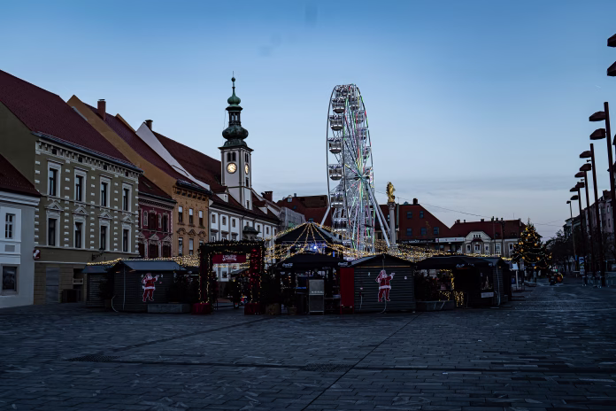 Maribor, Slovenia – December 07, 2024: A Christmas market with stands and a ferris wheel in Maribor, Slovenia