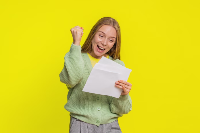 Middle-aged mature woman open envelope take out letter reads it feel happy. Career growth advance promotion, bank loan approve, monetary award, long-awaited invitation great news on yellow background