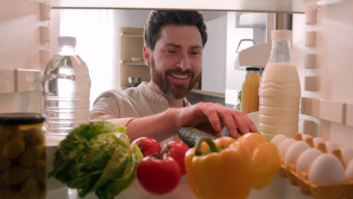 Point of view POV inside refrigerator hungry Caucasian man guy male chef open fridge with healthy vegetables choosing searching take eat apple eating fruit at home kitchen food delivery health diet. High quality 4k footage