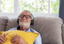 Glasba proti demenci: presenetljivi učinki prijetne navade Senior retirement man listen to music using headphone feeling happy in his home
