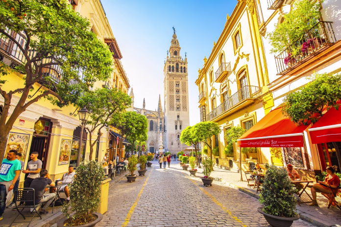 Seville, Spain - 6 March 2020: Sunny Seville street and scenic view of Giralda tower