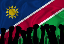 Da, prav ste prebrali: V Namibiji Adolf Hitler znova meri na zmago Silhouette of raised arms and clenched fists on the background of the flag of Namibia. The concept of power, conflict. With place for your text. 3D rendering