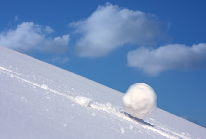 snow-ball-slides-downhill-and-speeds-up-stockpack-istock Snow ball slides downhill and speeds up.