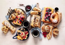 Predelane maščobe niso nevarne? Novo odkritje še enkrat zamajalo tehtnico Table with various pastries and coffe cups on light backround. Top view.