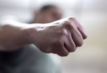 Dijaka v Kočevju napadla dva Roma, mu izbila zob in ga porinila v okno The angry man clenched his fist. Concept of violence.