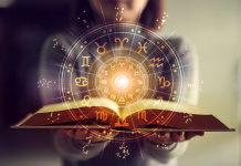 Dve horoskopski znamenji, ki ju pred novim letom čaka preobrat Woman holding a astrology book. Astrological wheel projection, choose a zodiac sign. Astrology esoteric concept.