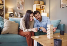 5 manj znanih družabnih iger za pare Beautiful young couple in love having fun playing block stacking balance game while relaxing and enjoying spending leisure time together at home