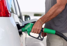 Izjemna novica! Bencin najcenejši po kar dveh letih close up of a man using a gas pump to refuel vehicle during energy crisis