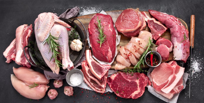 Different types of raw meat - beef, pork, lamb, chicken on dark background. Top view, copy space