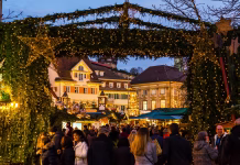 Obiskal je več kot trideset božičnih sejmov v Evropi, TA je njegov najljubši Esslingen am neckar, Germany, December 17, 2019, Entrance gate to christmas market illuminated by night with many people enjoying the beautiful mood