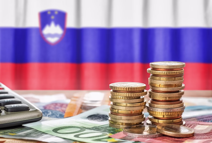 euro-banknotes-and-coins-in-front-of-the-national-flag-of-slovenia-stockpack-istock Euro banknotes and coins in front of the national flag of Slovenia