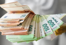 Največje investicije v osnovne šole – država bo sofinancirala skoraj 94 milijonov evrov Hand holding large fan of euro banknotes in 50, 100, and 200 denominations, concept of abundance, wealth, success and financial prosperity