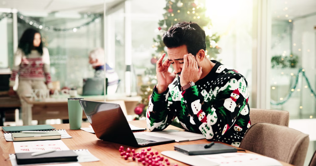 Headache, christmas and businessman in office with laptop for stress, burnout or fatigue for workload. Exhaustion, tired and financial advisor with migraine for documents and computer in xmas season.