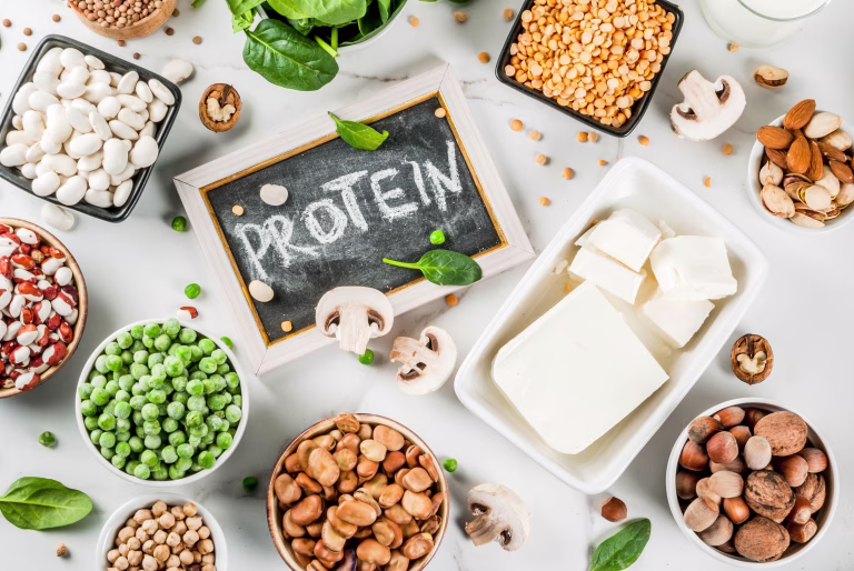 Healthy diet vegan food, veggie protein sources: Tofu, vegan milk, beans, lentils, nuts, soy milk, spinach and seeds. Top view on white table.