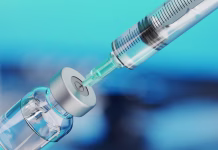 Sestavina, ki je v cepivih ključna: zakaj jo nekateri še vedno postavljajo pod vprašaj? Medical disposable syringe for vaccine injection and glass vial on blue blur background.
