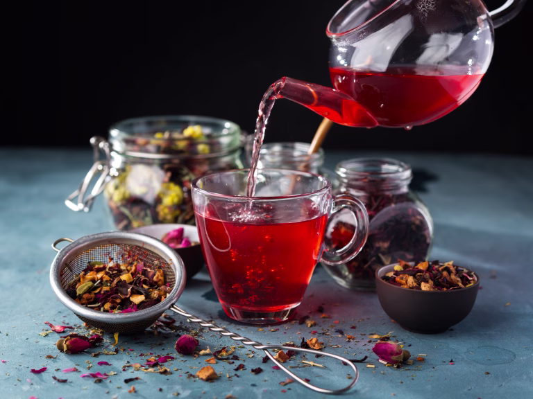 Process brewing tea, tea ceremony, Cup of freshly brewed fruit and herbal tea, dark mood .Hot water is poured from the kettle into a cup with tea leaves.