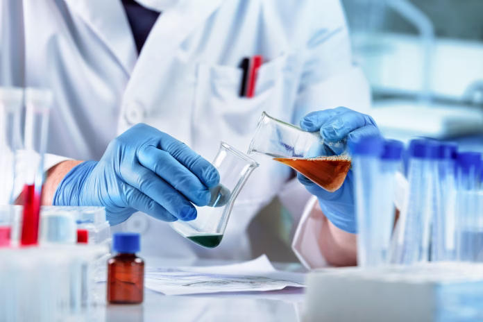 Scientist mixing chemical liquids in the chemistry lab. Researcher working whit fluids in flasks in the chemical laboratory
