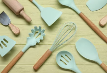 Vsi ga imamo v kuhinji: ampak ali je silikon res varen? Set of different kitchen utensils on yellow wooden table, flat lay