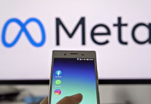 Meta od Appla ‘sunila’ najboljšega oblikovalca: kaj to pomeni za prihodnje naprave? Smartphone display with logo of Facebook, WhatsApp and Instagram apps in hand against blurred META logotype on white monitor background: Tallinn, Estonia - October 29, 2021