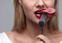 Se mesu ne morete odpovedati? Načini za zmanjšanje deleža mesa v prehrani Woman Eating Meat. Closeup of Healthy Hungry Girl With Beautiful Face, Red Lips Eats Delicious Grilled Meat. Female Mouth Biting Piece Of Tasty Beef Steak On Fork. Nutrition Concept. High Resolution