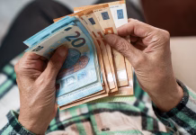 Na voljo štipendije v višini 3.600 evrov za študente te univerze A bundle of euros in the hands of an elderly pensioner. The concept of financial security in old age.