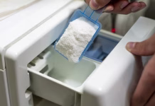 TO se zgodi, če dodajate preveč pralnega praška close up female hand pour the washing powder detergent into machine