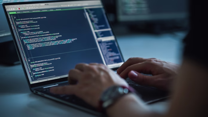 Close-up Focus on Person's Hands Typing on the Desktop Computer Keyboard. Screens Show Coding Language User Interface. Software Engineer Create Innovative e-Commerce App. Program Development