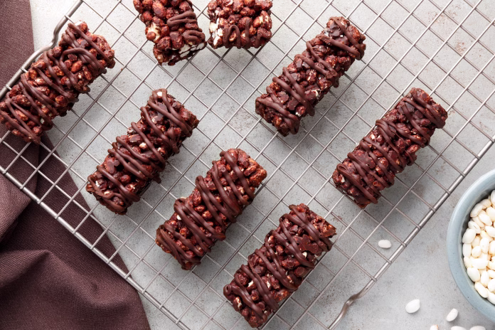 Delicious chocolate puffed rice bars on gray textured table, flat lay