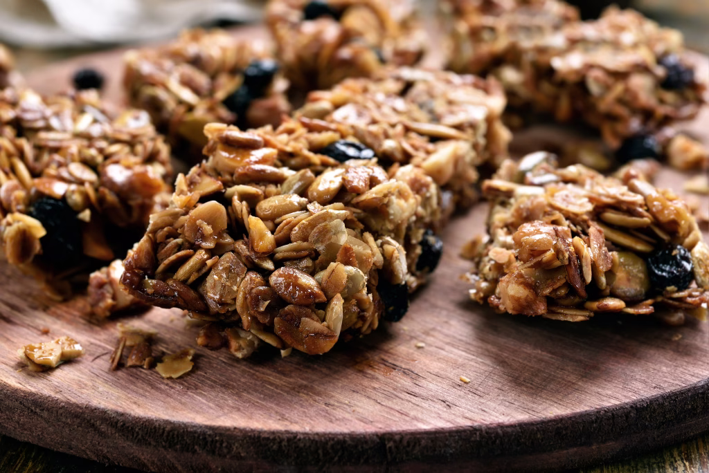 Granola pieces on wooden board, close up view