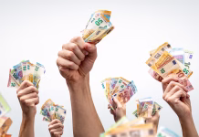 FURS od ‘prejemnikov sociale’ izterjal več kot 126 tisoč evrov, končali še niso Many hands holding several Euro banknotes. Isolated on a neutral background.