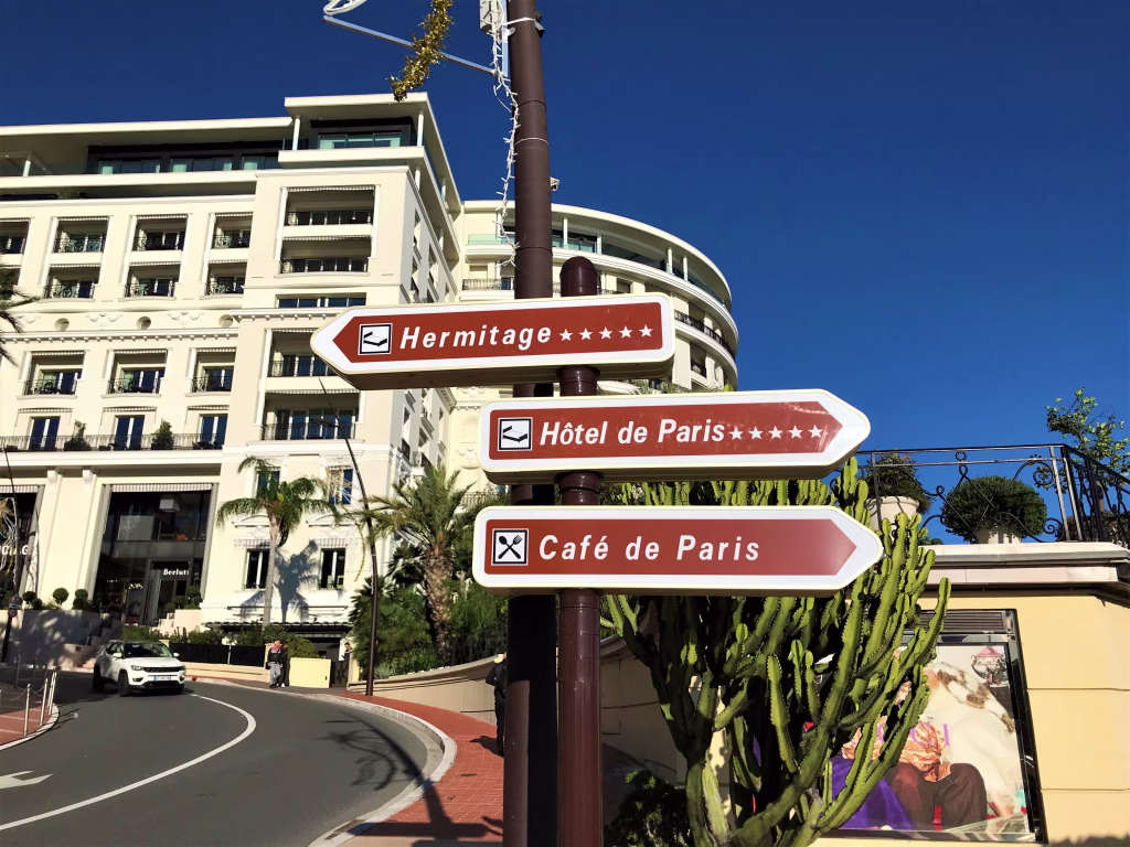 Monte Carlo, Monaco - December 22 2019: Hotel de Paris, Hermitage and Cafe de Paris information signs Monte Carlo street view with clear blue sky
