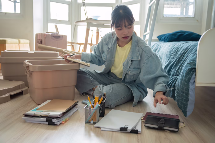 Student asian woman organize room unpack in dorm room college studentÂ moving to newÂ university dormitory or preparing to move out