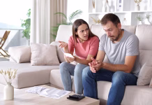 TE finančne navade lahko uničijo razmerje: so vam znane? Wife scolding husband checking expenses sitting on a couch at home
