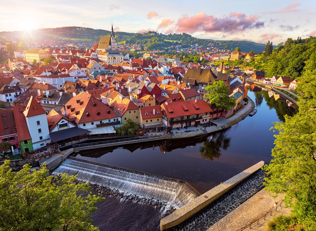Czech Krumlov, czech Republic. Evening panorama of beautifull old small town on the river Vltava. Picturesque landscape with authentic houses red tegular roofs and sunset sun rays